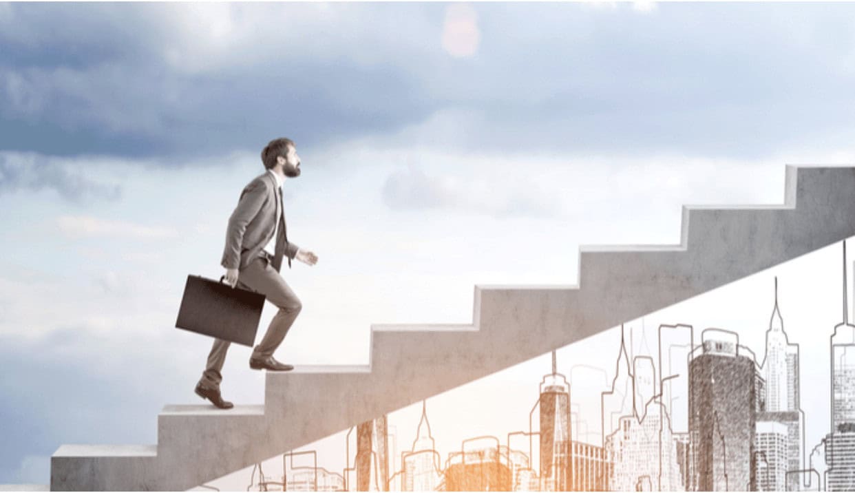 Motivated businessman ascending stairs toward success in a digital cityscape, symbolizing IT career growth with MyComputerCareer training programs for tech professionals.