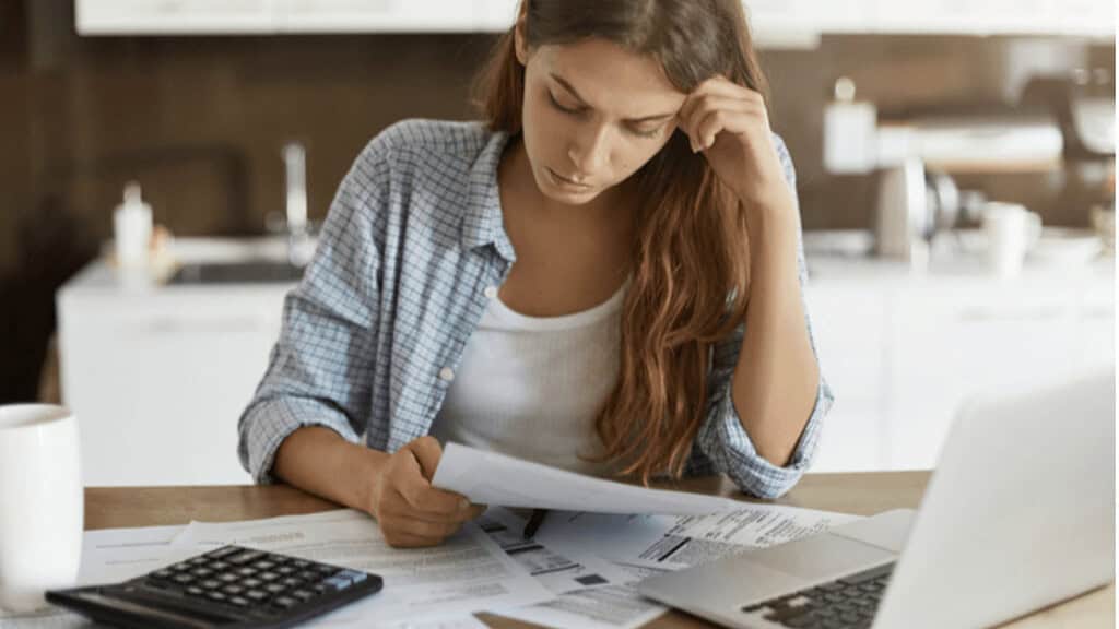A woman studying computer technology and certification materials at home, focusing on IT training and career advancement.