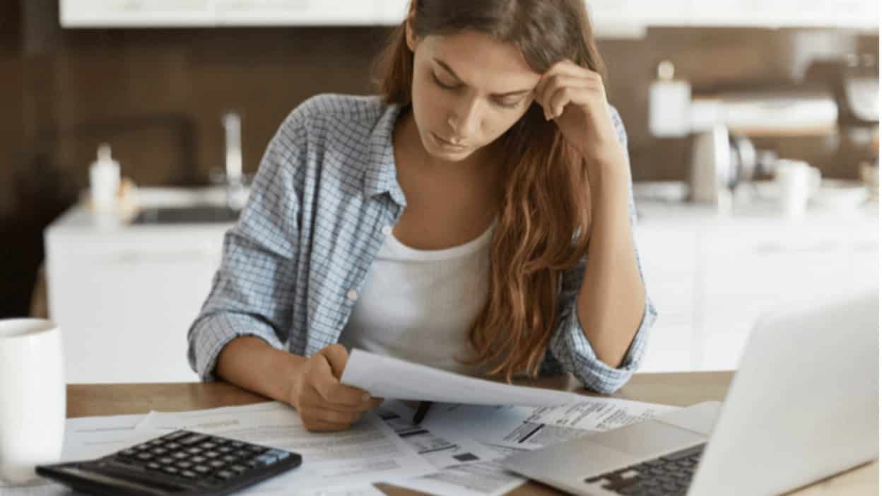 A woman studying computer technology and certification materials at home, focusing on IT training and career advancement.