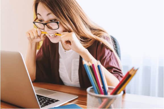 Young woman studying computer science at desk with laptop and stationery, emphasizing online IT training and career advancement.