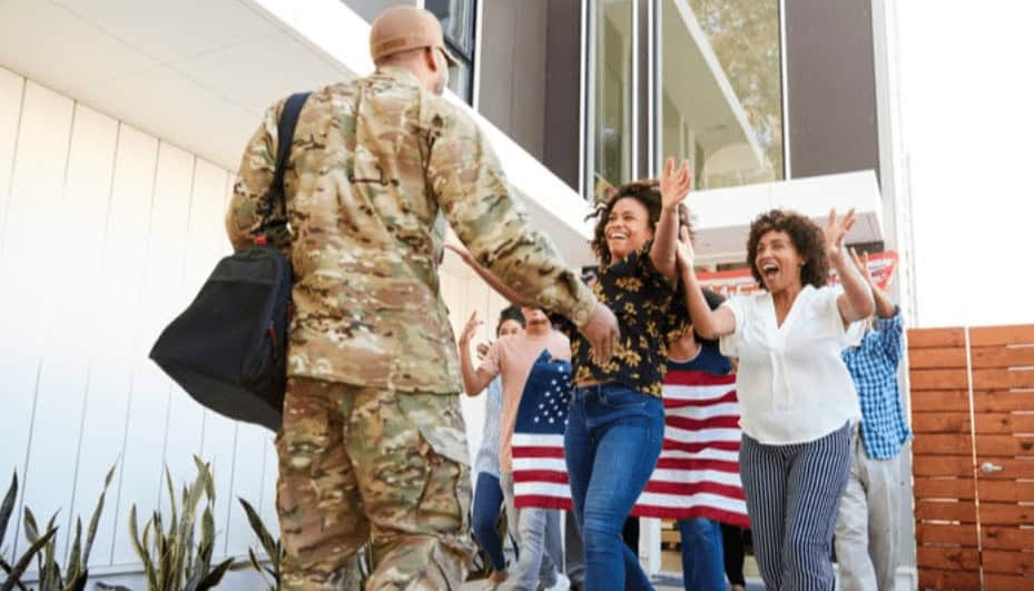Veteran welcoming new students at MyComputerCareer, emphasizing career training in IT fields, with happy students and an American flag in the background.