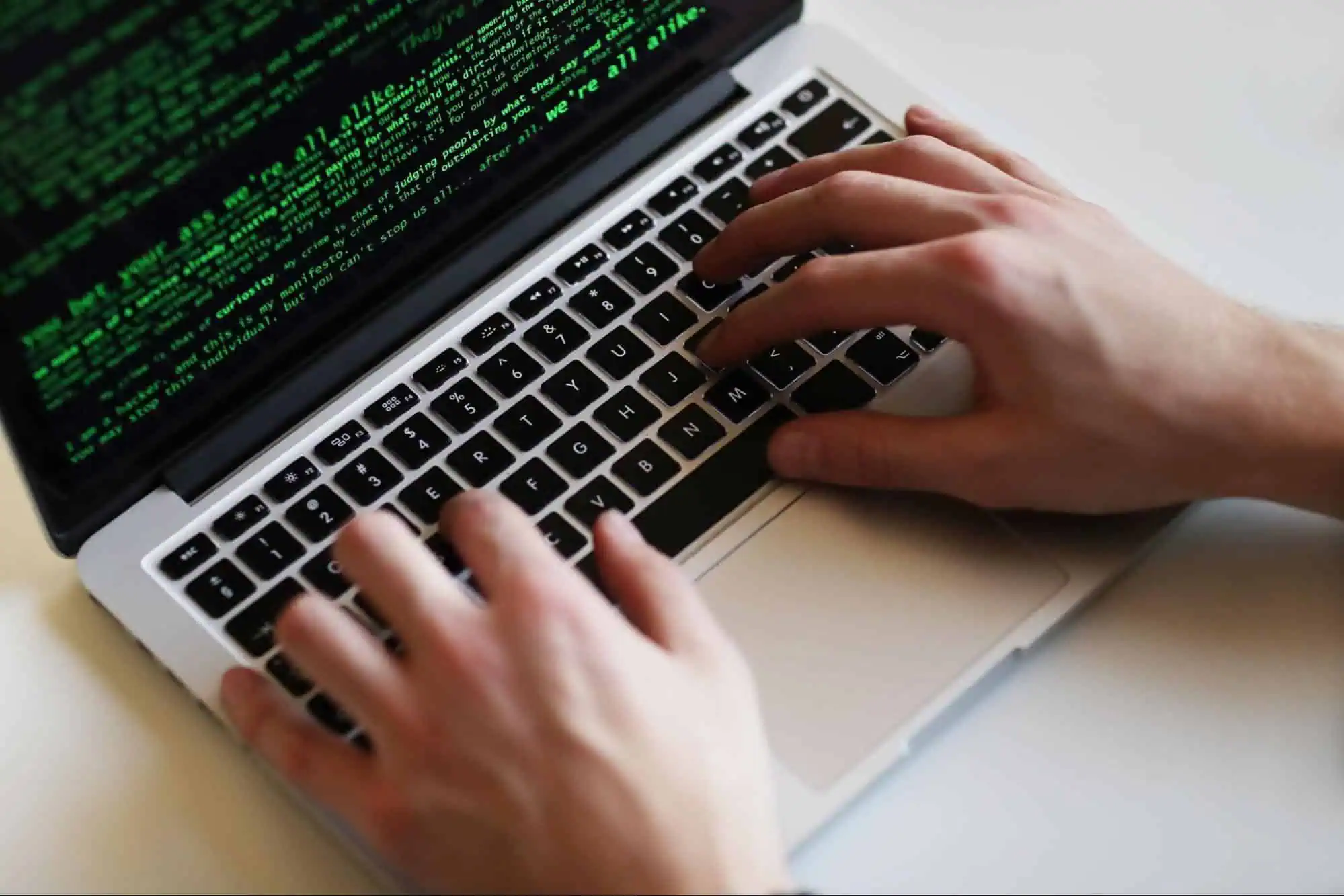 AI-generated image of a person typing on a laptop with green coding text on the screen, highlighting tech skills and coding education.