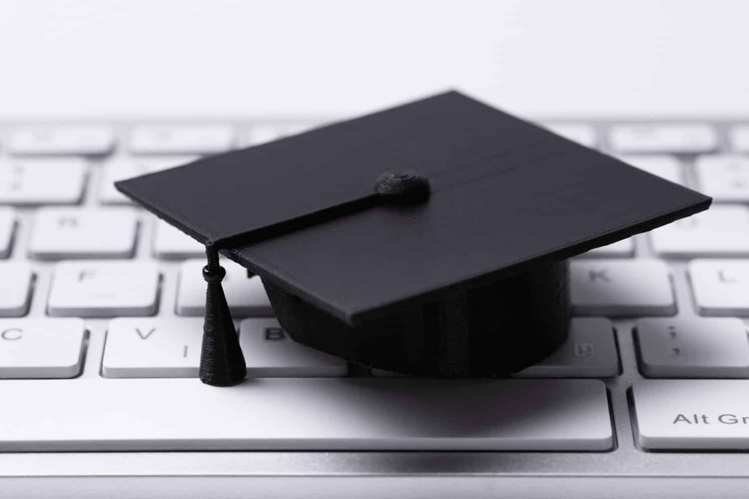 Graduation cap on computer keyboard, symbolizing online IT education and career training at MyComputerCareer.