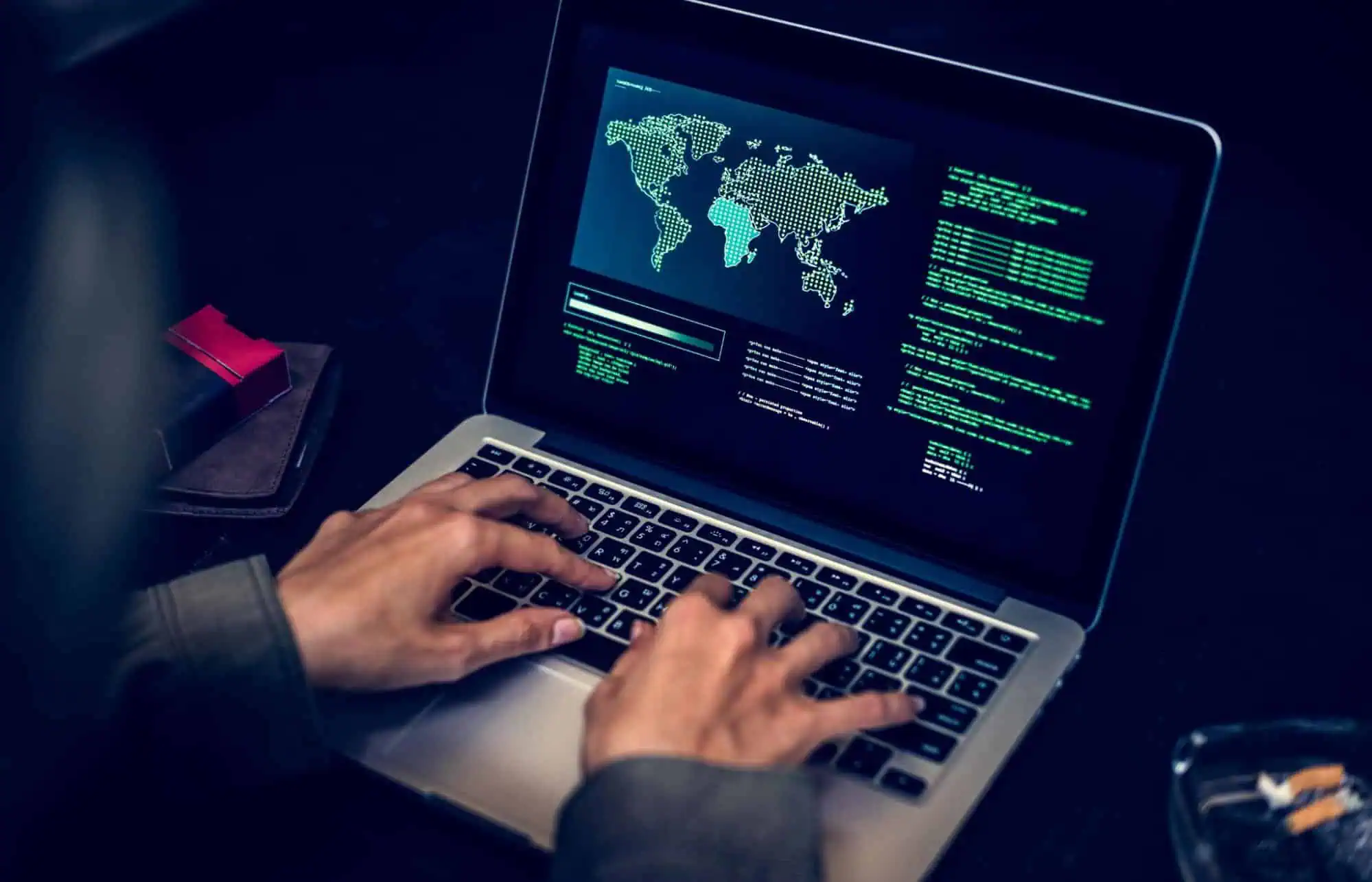 Hacking and cybersecurity training on a MacBook laptop, with a digital world map and code display, emphasizing IT and computer career education from MyComputerCareer.