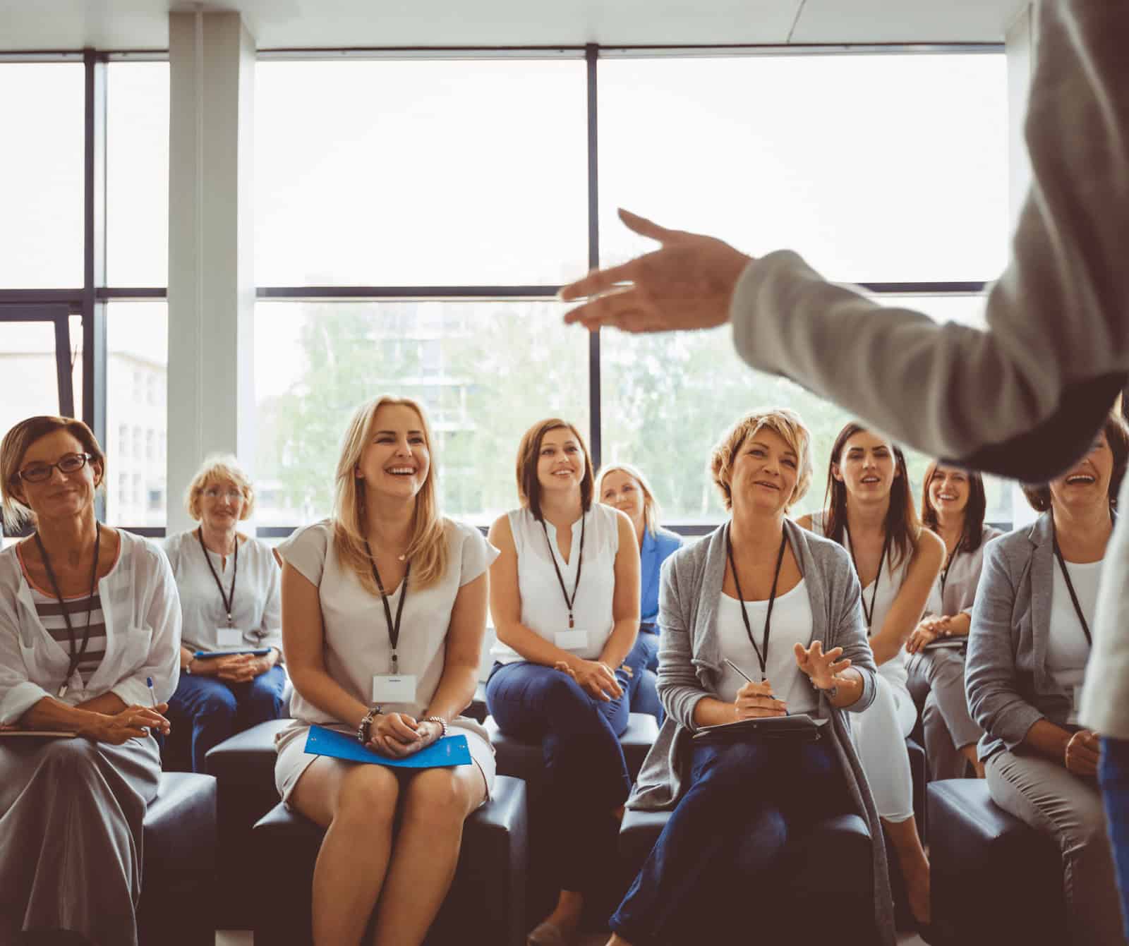 Professional woman giving presentation to diverse audience at a computer technology training seminar.