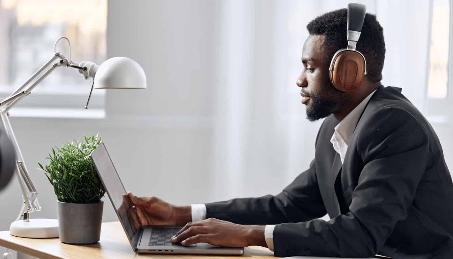 Professional man using a laptop with headphones, studying information technology at MyComputerCareer, emphasizing online IT training, tech certification, and career advancement in computer technology.