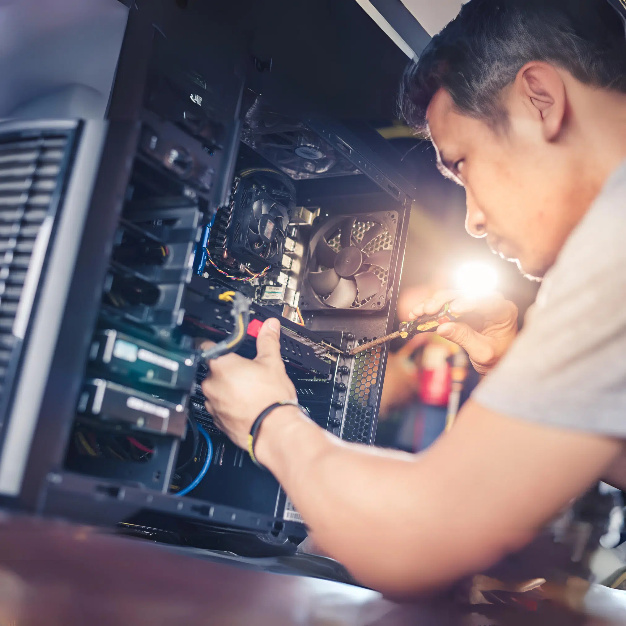 High school student repairing a desktop computer, focused on hardware installation and troubleshooting, representing IT technician training and computer repair education at MyComputerCareer.