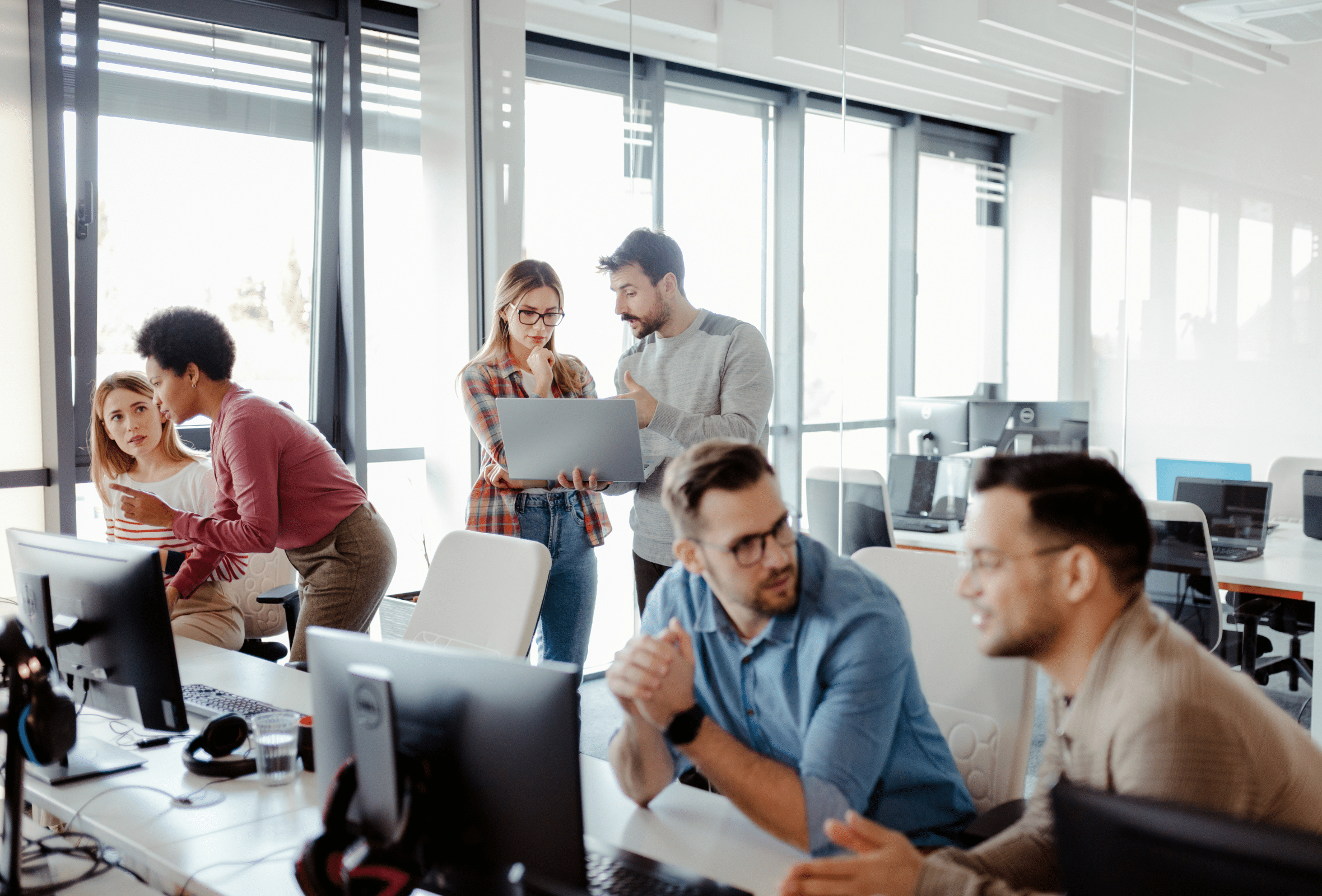 Collaboration among diverse students in a modern computer training classroom for IT and technology career education.
