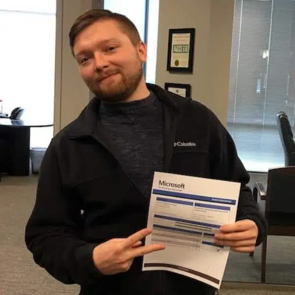 Person holding a Microsoft certificate indoors