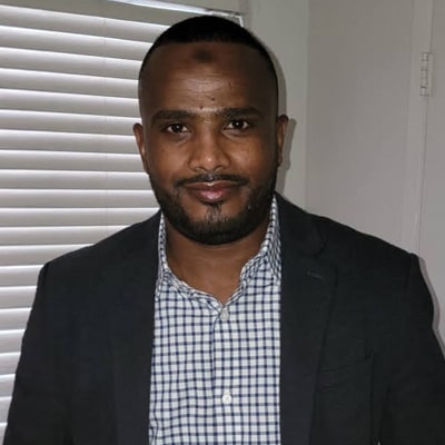 Man in blazer and checkered shirt indoors