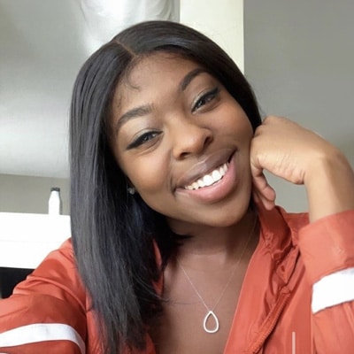Smiling woman in orange blouse taking selfie