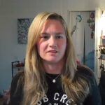 Blonde woman speaking indoors on webcam