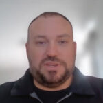 Man with shaved head and beard indoors