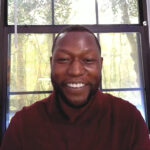 Smiling man in front of sunlit window