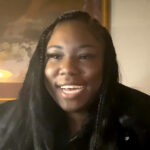 Smiling woman with long braids indoors