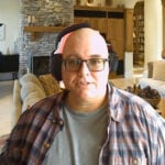 Man wearing headphones and glasses in a living room