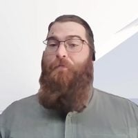 Bearded man with glasses speaking indoors