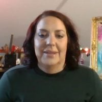 Woman with red hair speaking indoors