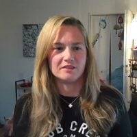 Blonde woman speaking indoors on webcam